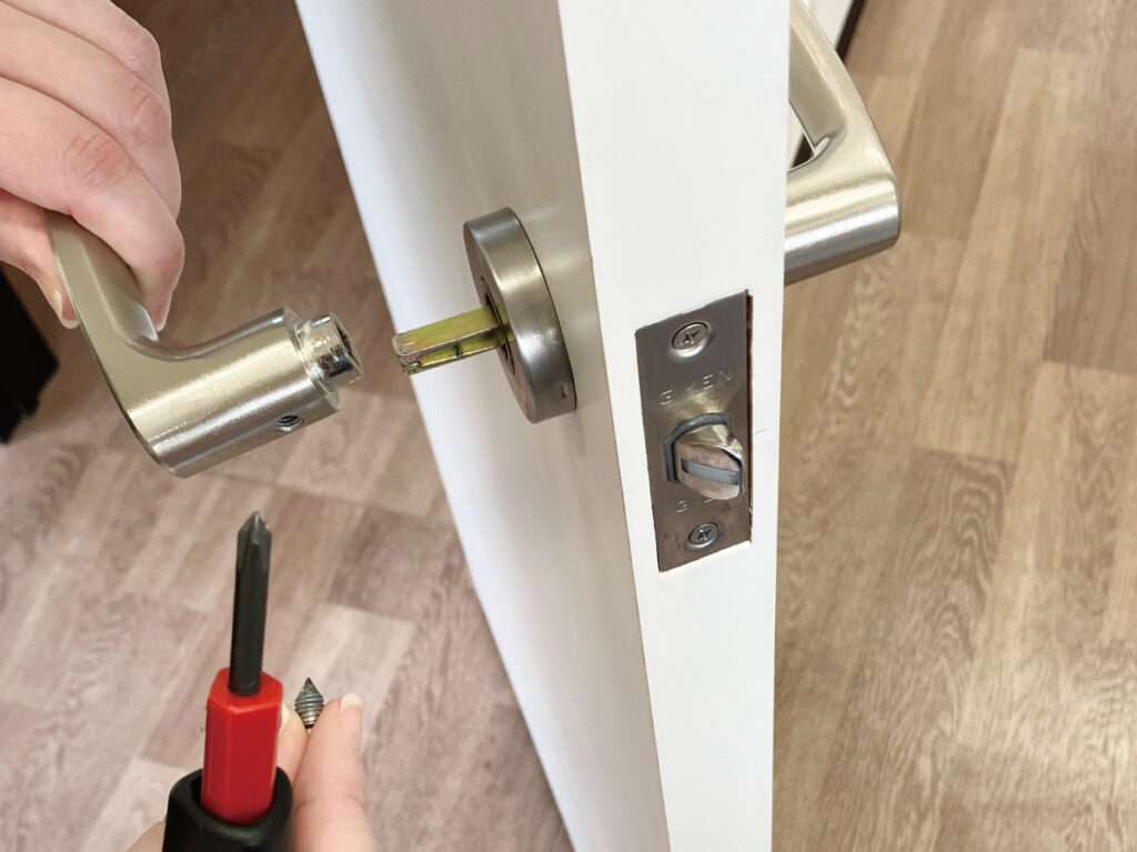 シール壁紙でドアをおしゃれにリメイクする。レバーハンドルを引き抜く。