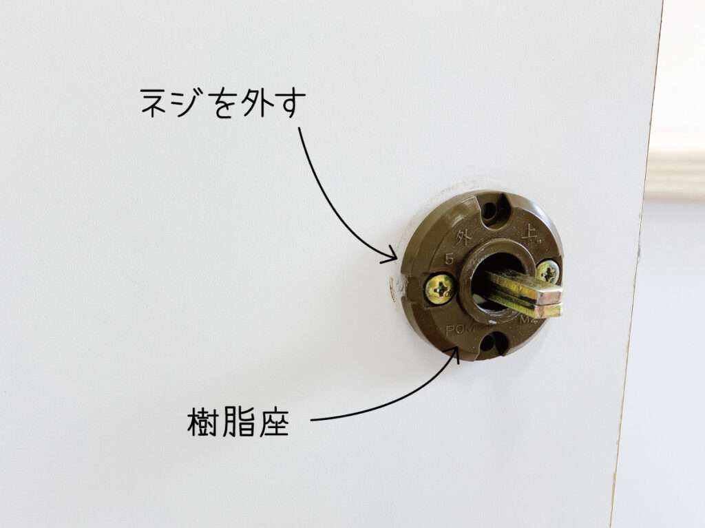 シール壁紙でドアをおしゃれにリメイクする。レバーハンドルの樹脂座のネジを外す。