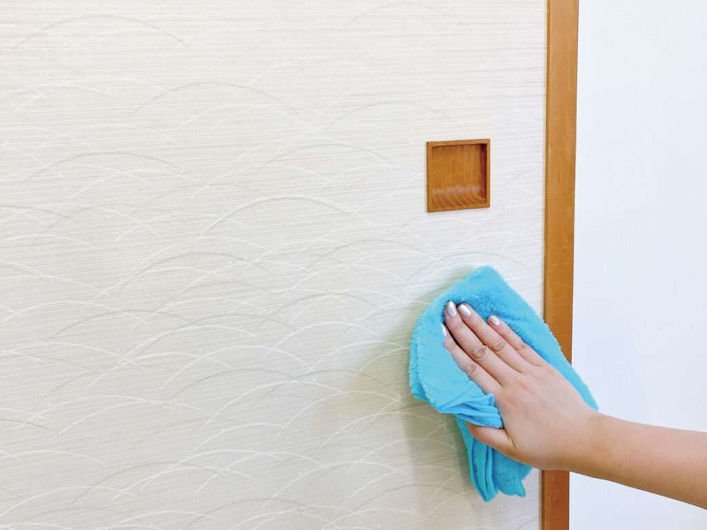 女性スタッフがふすまリメイクに挑戦・リメイク前にふすまを掃除する