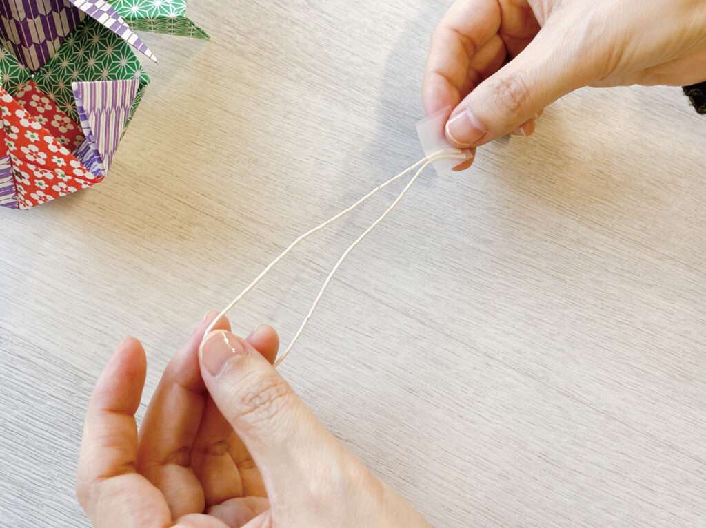 余った障子紙でクリスマスのオーナメント作り・紐を適当な長さに切ってセロテープで留める