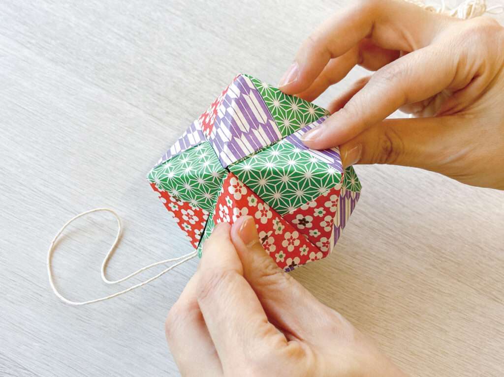 余った障子紙でクリスマスのオーナメント作り・つなぎ部分が緩まないよう、指でしっかり押さえる