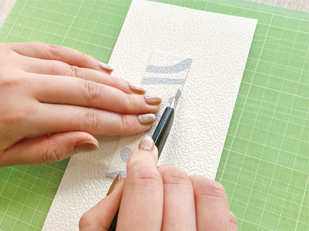 余ったふすま用リメイクシールで作る、かんたんしおり作り。厚紙に沿ってふすま用リメイクシールを切る。
